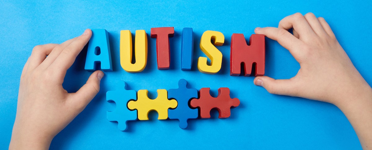 Autistic kid hands holding puzzle jigsaw and word autism, mental health concept. Autism spectrum, disorder. World autism awareness day.